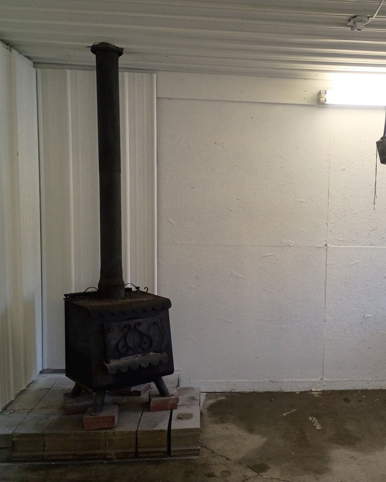 A garage wall and wood stove clean and white after fire and smoke damage cleanup