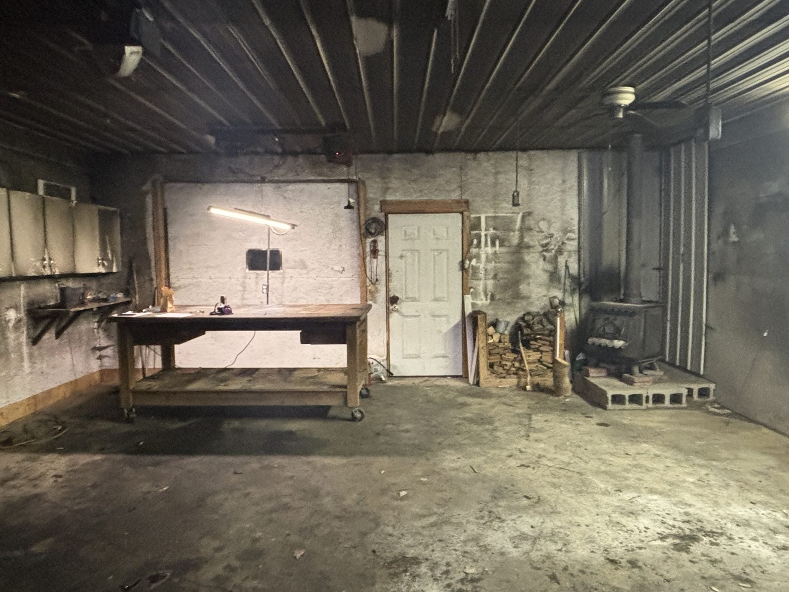 Garage workbench wall, ceiling, and wood stove covered in black soot after a fire