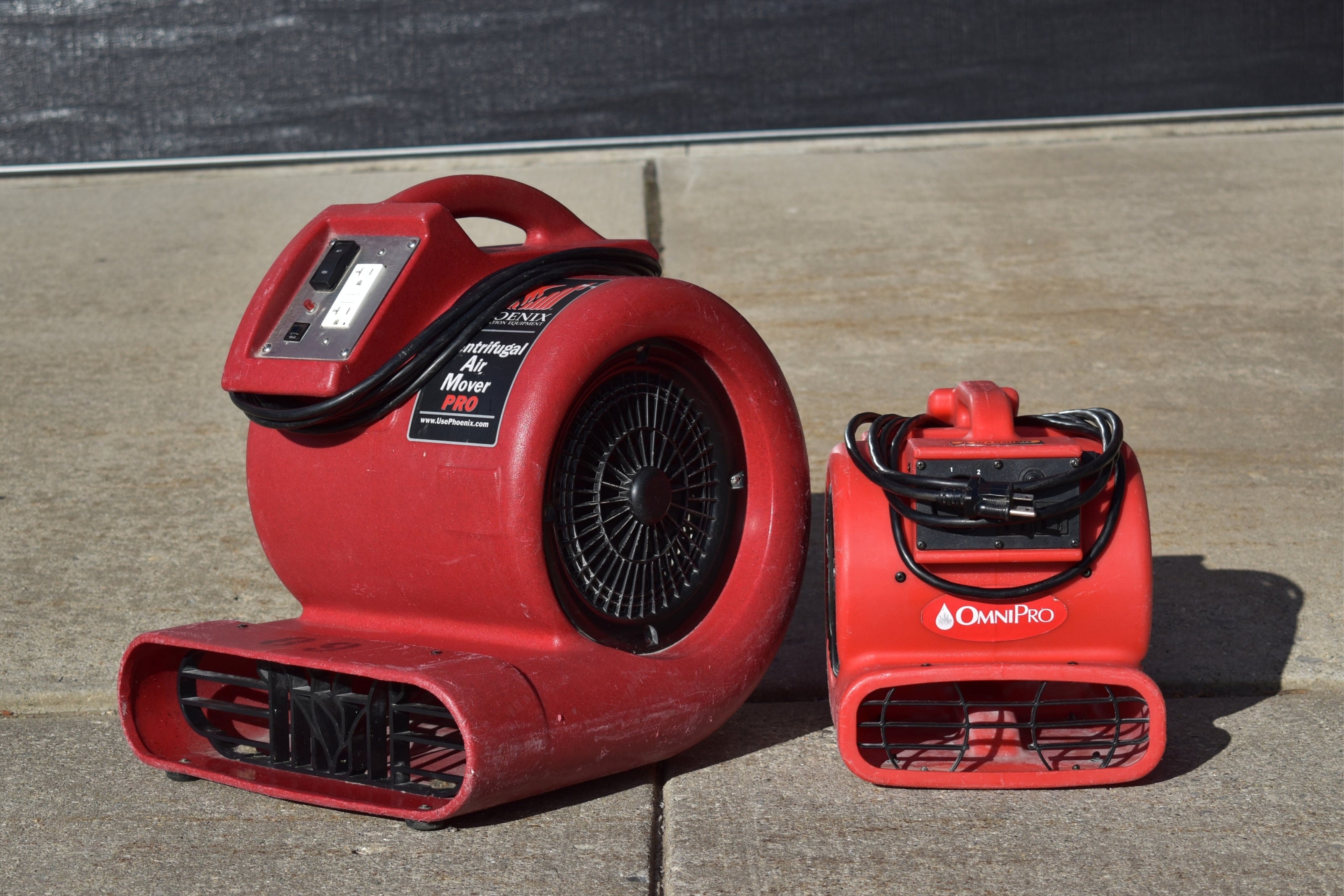 Two red air movers on the pavement outside the Bay Area Clean Care shop